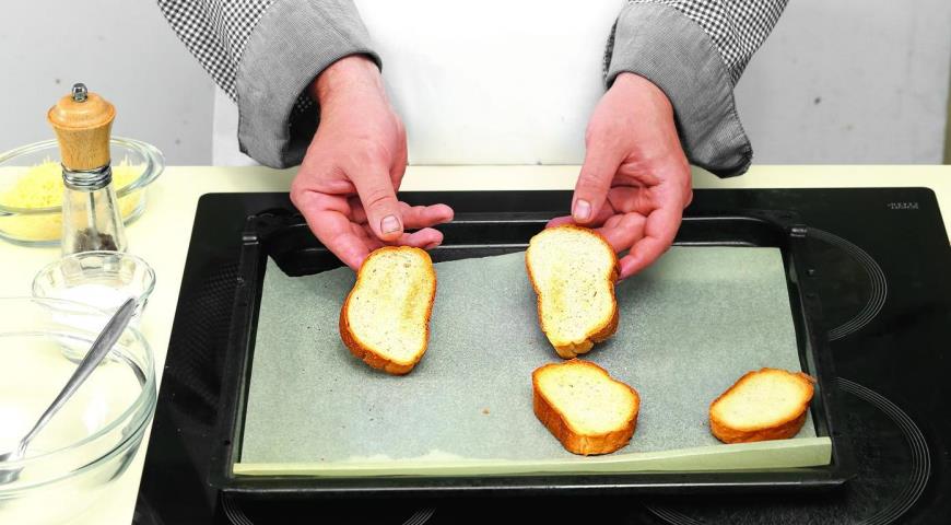 Разогрейте духовку до 200 °С. Застелите противень бумагой для выпечки. Положите на противень хлеб и поставьте в разогретую духовку. Пеките 3 мин., затем переверните на другую сторону и продолжайте жарить еще 3 мин. Хлеб должен подсушиться и слегка зазолот